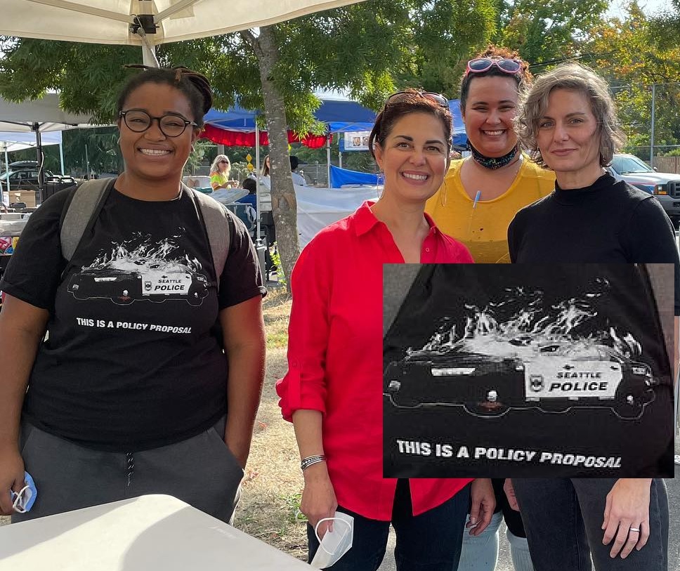 September 15th 2021, Nicole Thomas-Kennedy poses with her campaign manager Tye Reed wearing a t-shirt showing a burning Seattle Police patrol car and the text "THIS IS A POLICY PROPOSAL".
